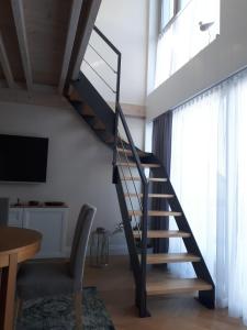 a staircase in a living room with a table and a chair at Apartament Morskie Wzgórze II in Mechelinki