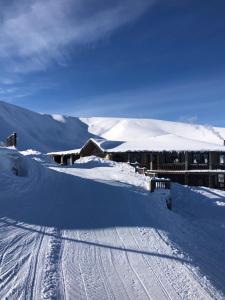a snow covered slope with a building in the snow at Вершина in Pilipets