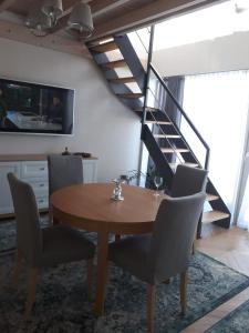 a dining room with a table and chairs and a staircase at Apartament Morskie Wzgórze II in Mechelinki