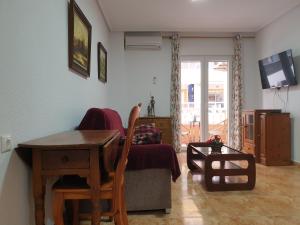 sala de estar con escritorio, mesa y sofá en Apartamento de vacaciones, en Torrevieja