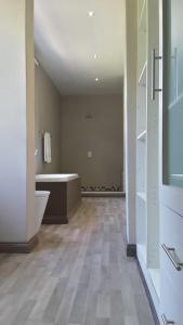 an empty bathroom with a tub and a sink at Versailles in Pretoria