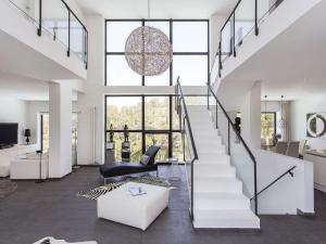 ein Wohnzimmer mit einer Treppe mit einem Stuhl und einem Sofa in der Unterkunft Architect modern design villa in Sitges Hills in Olivella