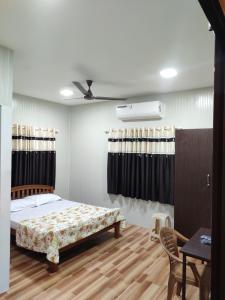 a bedroom with a bed and a table and a tableablish at Vidhara Rooms in Trivandrum