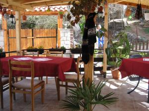 un patio con mesa y sillas con mantel rojo en Risto's Guest House en Ohrid