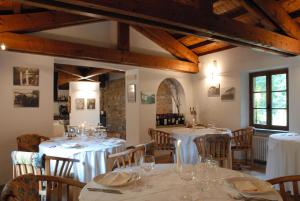 uma sala de jantar com mesas e cadeiras com toalhas de mesa brancas em Molino Del Torchio em Cuasso Al Monte