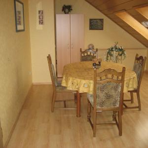 a dining room table and chairs with a yellow table cloth at Ferienwohnung in der Vulkaneifel in Ulmen