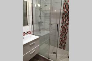a bathroom with a glass shower and a sink at appartement au Hameau du parc des thermes in Bagnoles de l'Orne