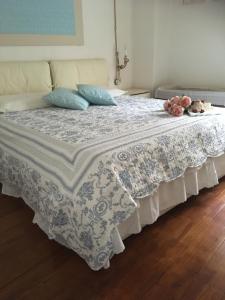 Una cama con sábanas azules y blancas y dos animales de peluche. en Casa Vacanze "Un sogno nel Blu'" en Baunei