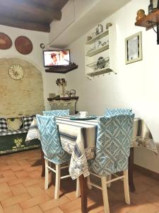 cocina con mesa con sillas y TV en Casa Vacanze "Un sogno nel Blu'" en Baunei