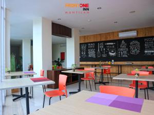 restauracja ze stołami, krzesłami i tablicą w obiekcie Front One Inn Muntilan w mieście Muntilan