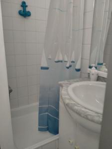 a bathroom with a sink and a toilet and a tub at Studio Penthouse Nieuwpoort in Nieuwpoort