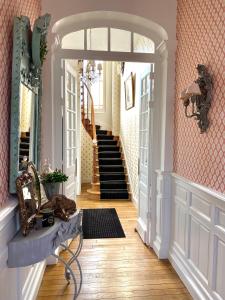 einen Flur mit Torbogen und Treppe in einem Haus in der Unterkunft Villa Aristide in Bergerac