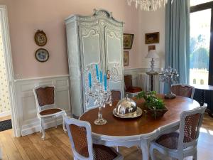 ein Esszimmer mit einem Tisch und einem großen Schrank in der Unterkunft Villa Aristide in Bergerac