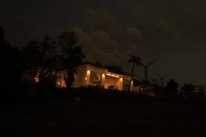 a house lit up at night with lights at Peakaavu Cottages in Idukki