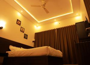 a bedroom with a ceiling fan and a bed at Peakaavu Cottages in Idukki