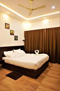 a bedroom with a bed with a heart pillow on it at Peakaavu Cottages in Idukki