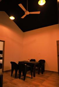 a dining room with a ceiling fan and a table and chairs at Peakaavu Cottages in Idukki