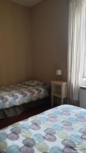 a bedroom with two beds and a table with a window at Gîte Le Campagnard in Saint-Germain-des-Bois