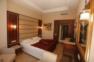 a bedroom with a bed and a television in it at Kronos Hotel in Golbası