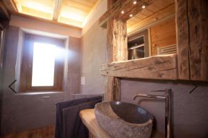 La salle de bains est pourvue d'un lavabo en pierre et d'une fenêtre. dans l'établissement Appartamenti al Ciariè, 