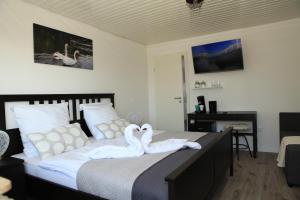 two swans sitting on a bed in a bedroom at Gästehaus zum Rhein in Rheinhausen