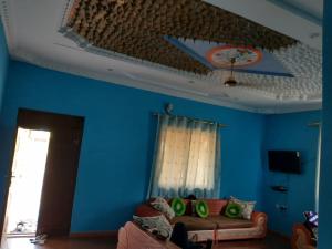 a living room with blue walls and a couch at Mkoani Guest House in Mkoani