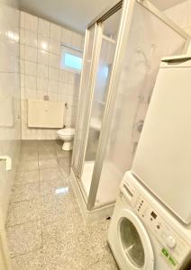 a bathroom with a washing machine and a toilet at Preiswertes zentrales WG-Zimmer in Ravensburg in Ravensburg