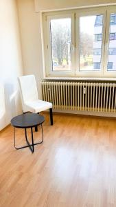 um quarto com uma cadeira, uma mesa e um radiador em Preiswertes zentrales WG-Zimmer in Ravensburg em Ravensburg