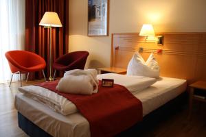 a hotel room with a bed and two chairs at Boulevard Hotel Altstadt Schwerin in Schwerin