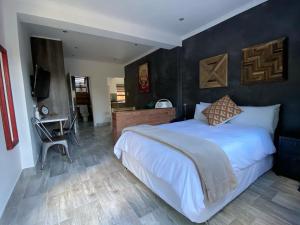 a bedroom with a large bed and a television at RElaxed city living in Port Elizabeth