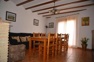 Casa Alhambras في مانزانيرا: غرفة طعام مع طاولة وكراسي وأريكة