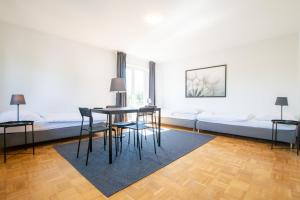 a living room with a table and chairs and a couch at RAJ Living - 1 , 3 and 4 Room Apartments - 20 min Messe DUS & Airport DUS in Meerbusch