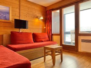 Hotelzimmer mit Sofa und TV in der Unterkunft Appartement cozy centre Alpe d'Huez in L'Alpe-d'Huez
