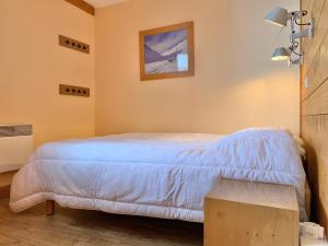 a bedroom with a bed and a picture on the wall at Appartement cozy centre Alpe d'Huez in L'Alpe-d'Huez