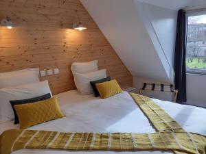 Cama grande en habitación con pared de madera en CHARMES EN VILLE Le Charme Authentique en Montluçon