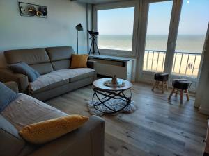 un salon avec un canapé et une table dans l'établissement zeedijk westende, à Middelkerke