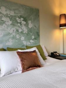 1 dormitorio con 1 cama y una gran pintura en la pared en RhönZeit Apartements und Zimmer, en Hilders