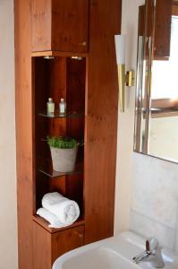 a bathroom with a sink and a shelf with towels at RhönZeit Apartements und Zimmer in Hilders