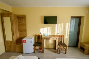a kitchen with a table and chairs and a refrigerator at Casa Domneasca Riana in Piteşti