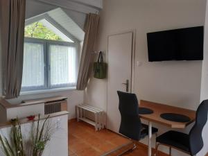 una pequeña sala de estar con mesa y ventana en Mona apartman, en Keszthely