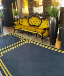 un sofá amarillo sentado en un piso en el vestíbulo en Hotel Fado en Gorzów Wielkopolski