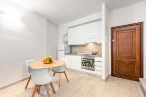 uma cozinha com mesa e cadeiras e uma cozinha com armários brancos em Duomo Confort Suite em Florença