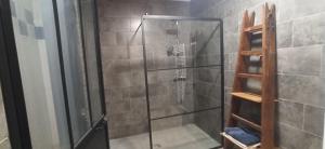 La salle de bains est pourvue d'une douche avec une porte en verre. dans l'établissement La Ferme du Père, à Kermorocʼh