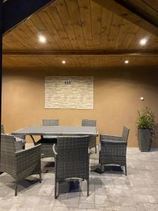 a table and chairs in a room with a wall at Vir&aacute;g Vend&eacute;gh&aacute;z in Poroszl&oacute;