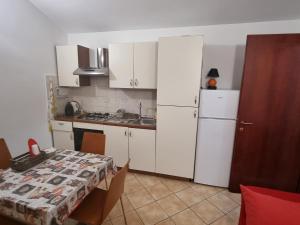 una cucina con tavolo e frigorifero bianco di casa Federica a Olbia