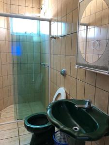 a bathroom with a green sink and a toilet at Cobertura Frente Mar in Porto Belo