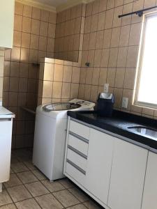 a kitchen with a washing machine and a sink at Cobertura Frente Mar in Porto Belo
