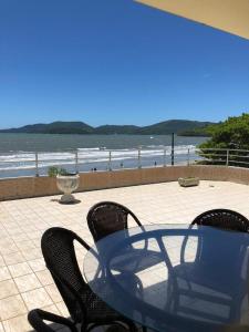 a table and chairs sitting on a patio near the beach at Cobertura Frente Mar in Porto Belo