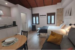 a bedroom with a bed and a table and a kitchen at Barbacana, dieciocho in Baeza