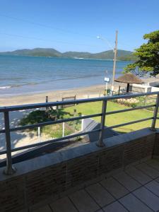 einen Balkon mit Blick auf den Strand und das Meer in der Unterkunft Apto Frente Mar in Itapema